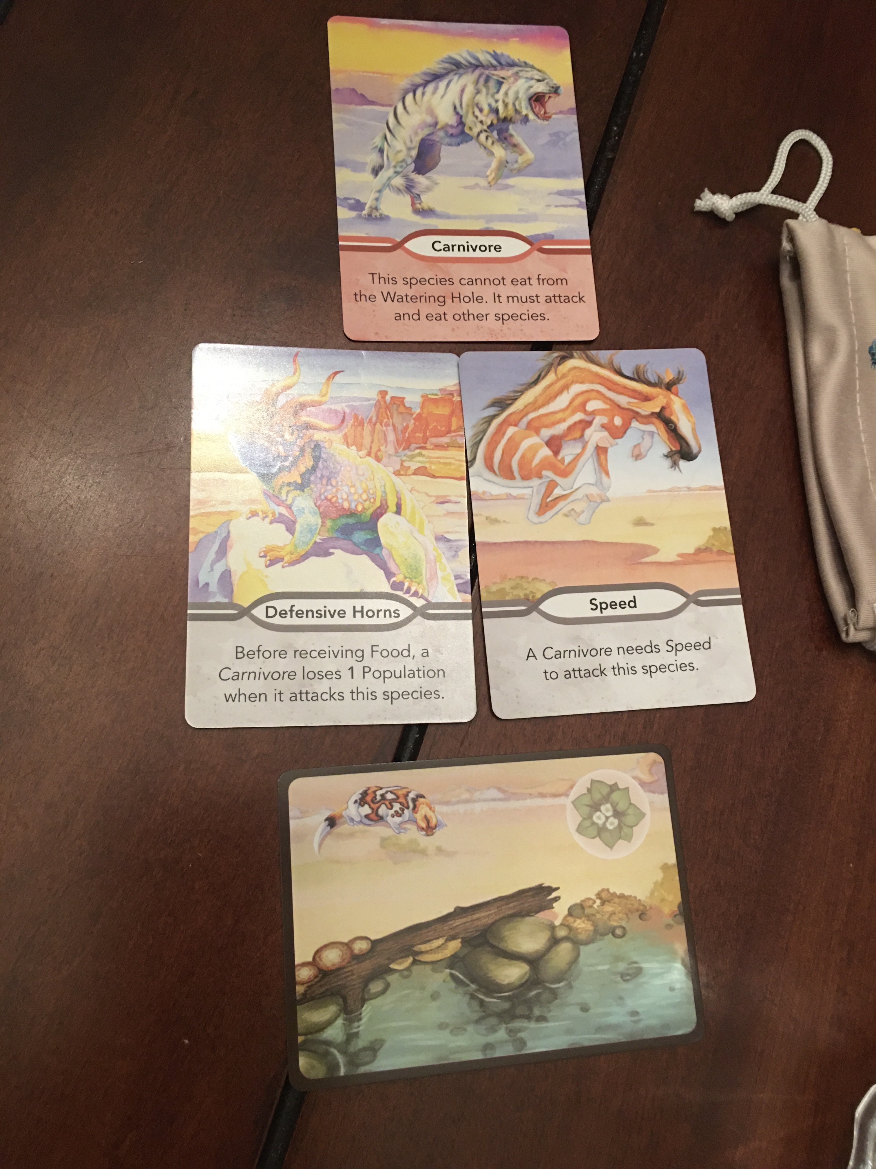 A carnivore card over a species card with the traits of defensive horns and speed. 